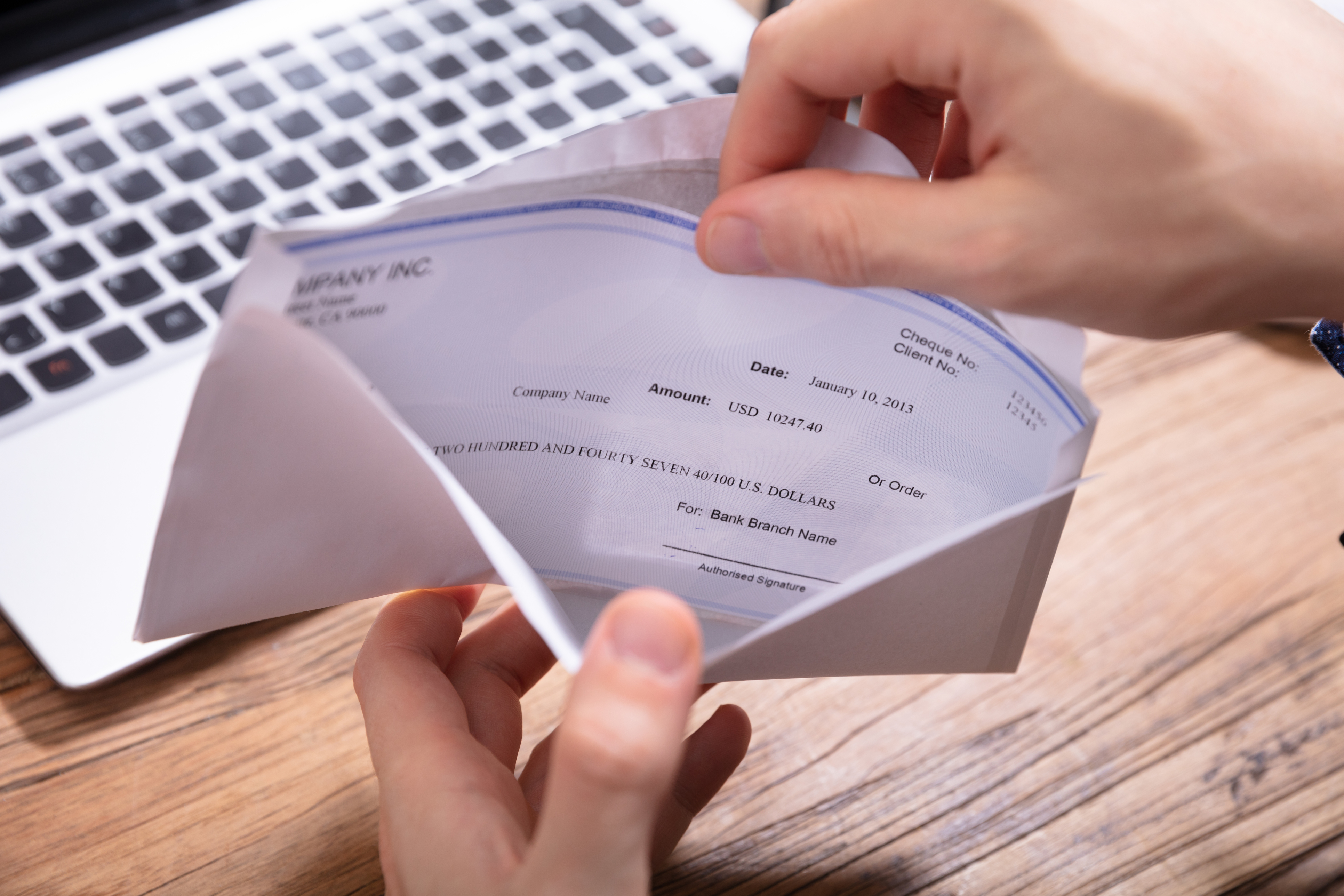 Person’s Hand Removing Paycheck From The Envelope Edge Financial