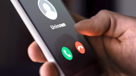 Phone call from unknown number late at night. Scam, fraud or phishing with smartphone concept. Prank caller, scammer or stranger. Man answering to incoming call. Hoax person with fake identity.