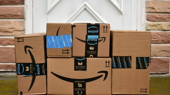 Amazon packages stacked in front of a door.